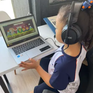 Criança com fones de ouvido em sessão de treinamento auditivo