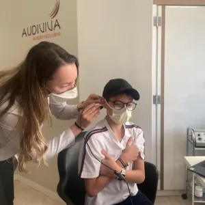 Fonoaudióloga operando audiômetro durante exame de audição