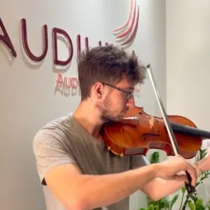 Músico tocando violino, paciente do programa de saúde auditiva do músico