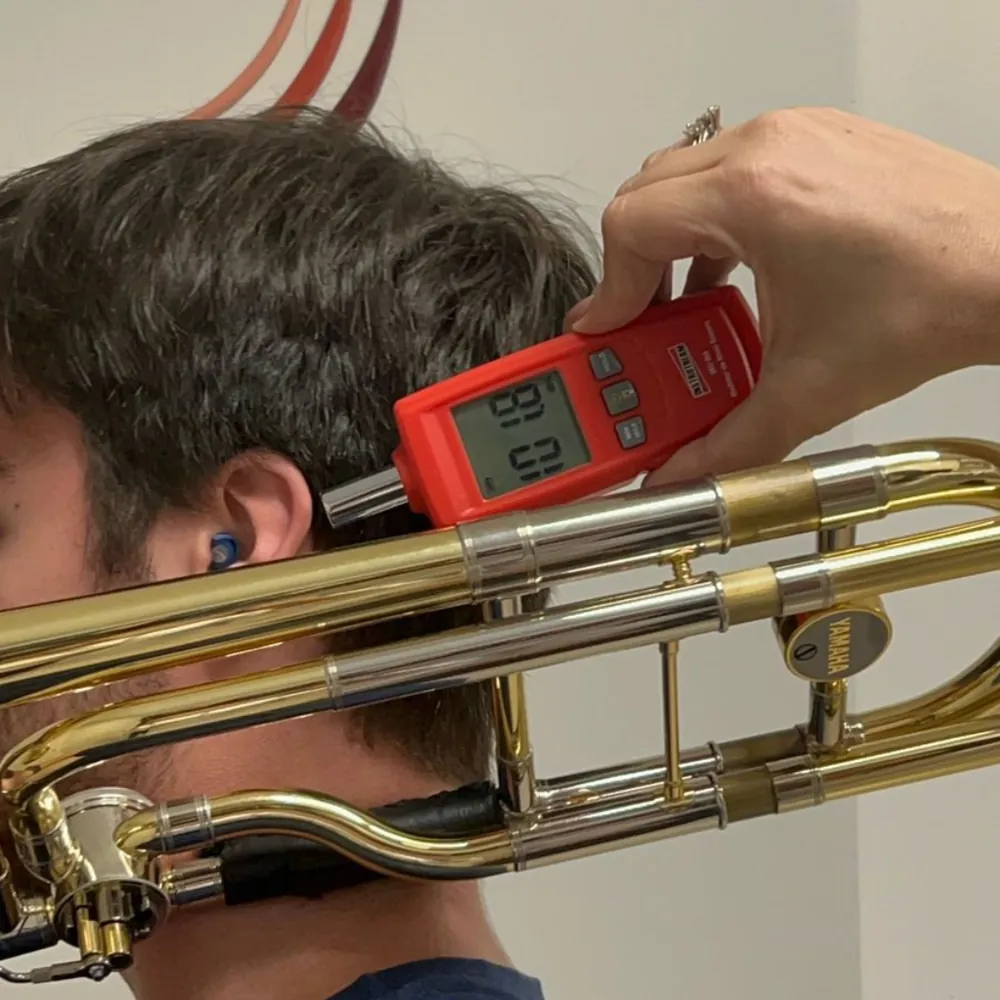 Fonoaudióloga medindo a intensidade sonora de um trombone para proteger a audição do músico